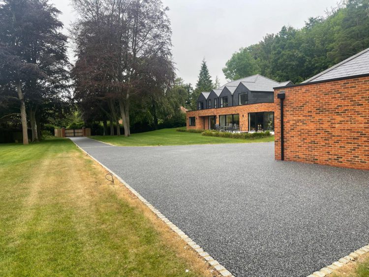 Dark resin bound driveway at a large modern brick house